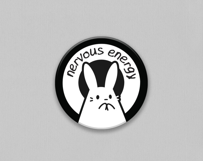 K&ouml;nnte beinhalten: Schwarzer und wei&szlig;er Knopf mit einem wei&szlig;en Kaninchen mit einem nerv&ouml;sen Ausdruck und dem Text "nervous energy" um das Kaninchen herum.