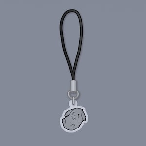 May include: A black phone charm with a gray cartoon bunny design.