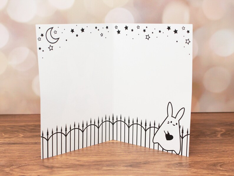 Inside of the card features a cute illustration of the ghost rabbit carrying a black heart and a starry sky.