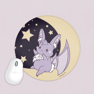 May include: A round mouse pad with a purple bat with white fur on a crescent moon background. The moon is yellow and the background is black with white stars. The text "nhuudog.com" is in the bottom right corner.