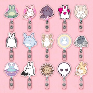 May include: Set of 18 colorful enamel pins featuring various cute animal designs, including bunnies, a frog, a skull, a sun, and a whale. The pins are attached to metal clasps.
