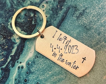 "Handgestempelter Schlüsselanhänger zur Taufe: ""I linkss it in the water"", personalisiertes Datum."