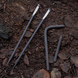 May include: Four metal tools for camping or outdoor use. Two long, thin tools with a hook at the end, one curved tool with a serrated edge, and one straight tool with a pointed end.
