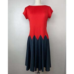 Könnte beinhalten: Ein rotes und schwarzes Kleid mit einem gewellten Saum. Das Kleid hat kurze Ärmel und einen runden Ausschnitt.