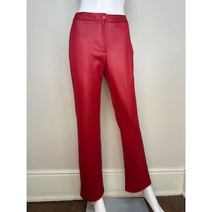 May include: Bright red, straight-leg pants with a button closure at the waist. The pants are made of a smooth, possibly faux leather material. The pants are displayed on a mannequin.