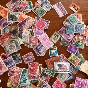 300 sellos postales antiguos de EE. UU. de la década de 1900 a la de 1970, usados y sin usar. También incluye algunos sellos navideños antiguos.
