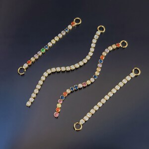 May include: Three gold chains with colorful gemstones. Each chain has a loop at each end.