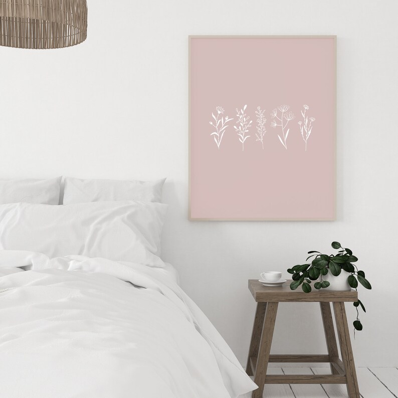 May include: A blush pink framed print with a white line drawing of five different types of flowers.