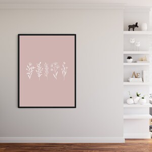 May include: A framed print with a blush pink background and white line drawings of five different flowers.