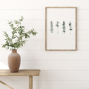 May include: A framed watercolor print of a row of five stylized trees in shades of green and blue against a white background.