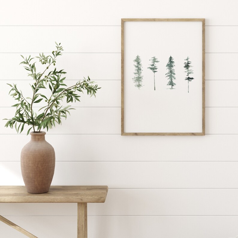May include: A framed watercolor print of a row of five stylized trees in shades of green and blue against a white background.