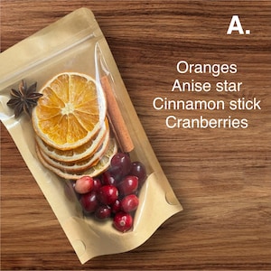 Könnte beinhalten: Eine transparente Plastiktüte gefüllt mit getrockneten Orangenscheiben, Cranberries, einem Zimtstange und einem Sternanis. Die Tüte ist mit "A. Orangen, Sternanis, Zimtstange, Cranberries" beschriftet.