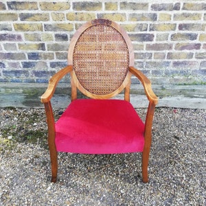 A Retro Vintage Early 20th Century Rattan Armchair with a Red Velvet Seat