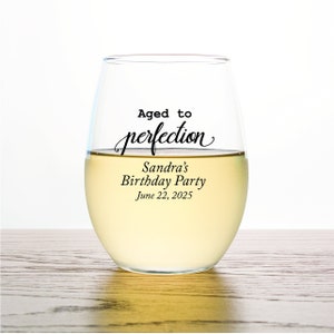 Op de afbeelding: Een helder glazen wijnglas met de tekst "Aged to perfection" en "Sandra's Birthday Party June 22, 2025" erop gedrukt.