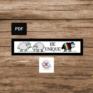 Può includere: Schema di punto croce in bianco e nero con tre pecore bianche e una pecora nera con una bandiera italiana sulla schiena. Il testo "BE UNIQUE" è scritto in lettere nere.