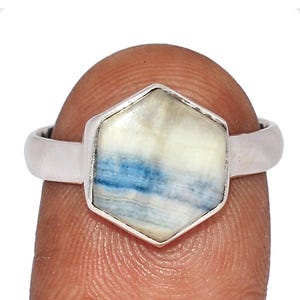 May include: A silver ring with a hexagonal blue and white gemstone.