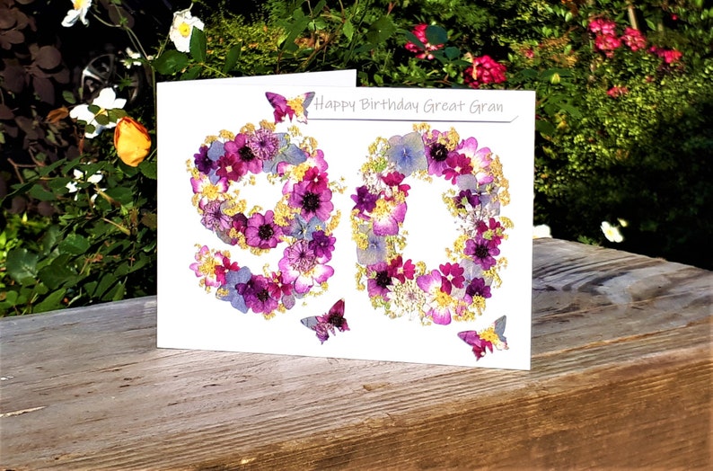May include: A white card with the number 90 made of pressed flowers. The card says "Happy Birthday Great Gran" at the top.