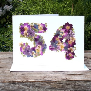 Number 54 card, pressed flowers designed into the number 54. Printed onto 300gsm matt white card, there are no real flowers on this card. Blank inside with the option to add a personalised gold and silver leaf insert. Card size 5 x 7 inches.