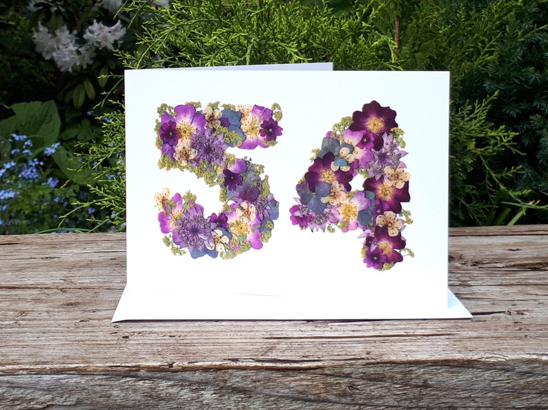 Number 54 card, pressed flowers designed into the number 54. Printed onto 300gsm matt white card, there are no real flowers on this card. Blank inside with the option to add a personalised gold and silver leaf insert. Card size 5 x 7 inches.