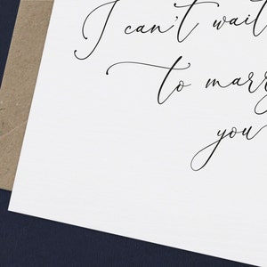 May include: A white card with black calligraphy that reads "I can't wait to marry you".