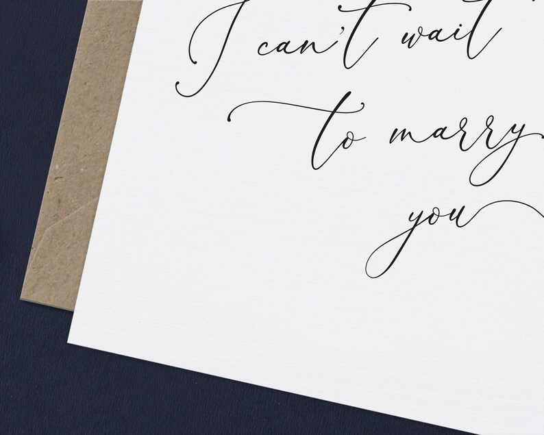 May include: A white card with black calligraphy that reads "I can't wait to marry you".