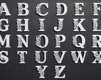 May include: A complete set of white capital letters from A to Z, arranged in rows. Each letter features a decorative cutout pattern of roses and leaves integrated into the left side of the character design, creating a consistent floral aesthetic.