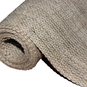 May include: A roll of natural brown burlap fabric. The fabric is woven with a rough texture and is rolled up tightly.