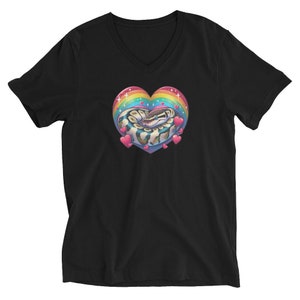 Könnte beinhalten: Schwarzes V-Ausschnitt-T-Shirt mit einem Regenbogenherz-Design, in dem sich eine eingerollte Schlange befindet. Das Herz hat rosa, blaue, grüne, gelbe und orangefarbene Streifen. Um das Herz herum befinden sich kleine rosa Herzen.