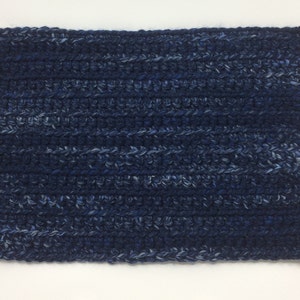 May include: A rectangular crochet piece featuring a variegated yarn pattern in shades of dark navy blue, royal blue, and light blue. The texture consists of horizontal rows of dense, interlocking stitches creating a thick, uniform fabric surface.