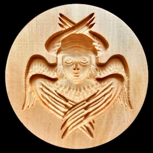 Puede incluir: Escultura redonda de madera de un ángel con alas extendidas y manos cruzadas. El rostro del ángel es sereno, con los ojos cerrados y una expresión suave. La talla es de color marrón claro, con líneas detalladas.