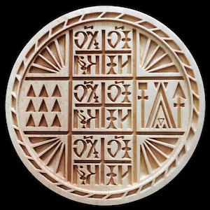 May include: A round, wooden carving with a complex geometric design. The light brown carving features a central square divided into smaller squares with stylized symbols and text. The outer edge has a sunburst pattern and a decorative border.