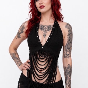 May include: Black halter top with fringe detail. The top features a deep V-neckline with silver stud accents. The fringe cascades down the front, creating a layered effect. The top is part of a two-piece outfit.