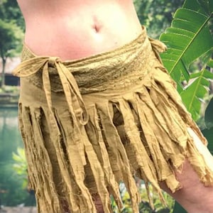 May include: A light olive green wrap skirt with a fringed hem. The skirt is tied at the waist with long fabric ties. The top of the skirt has a textured, lace-like design.