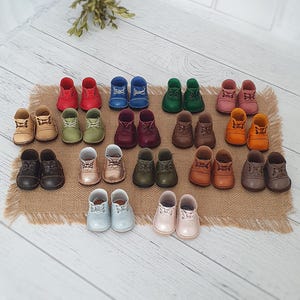 Könnte beinhalten: Eine weiße Keramiktasse mit schwarzem Henkel und dem Text "But First, Coffee" in fetter, schwarzer Schrift. Die Tasse steht auf einer Holzoberfläche. Die Tasse ist 10 cm hoch.