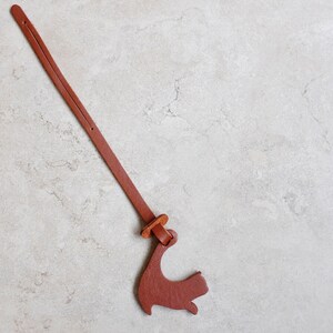 Peut inclure: Un marque-page en cuir marron avec un motif d&eacute;coup&eacute; en forme d'oiseau. Le marque-page est attach&eacute; avec une ficelle en cuir marron.