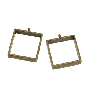 May include: Two antique gold-toned metal square pendant frames with a loop at the top for hanging.