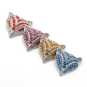 May include: Four fox-shaped metal embellishments arranged in a diagonal line. Each piece features a silver-toned frame encrusted with small, sparkling rhinestones in red and white, purple, amber, and blue, creating a vibrant, textured appearance.