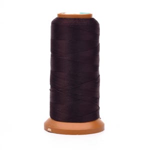 May include: A spool of dark brown thread, tightly wound and ready for use. The thread is wrapped around a wooden spool with a light brown base and a small, light blue piece at the top. Ideal for sewing and crafting projects.