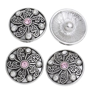 May include: Three circular silver-toned metal snap buttons featuring a central pink rhinestone surrounded by swirling filigree patterns and six clear accent rhinestones, alongside one plain silver-toned snap button back with a central stud.
