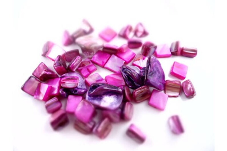 May include: A collection of pink and purple iridescent shell tiles. The tiles are various shapes and sizes, including squares and rectangles.