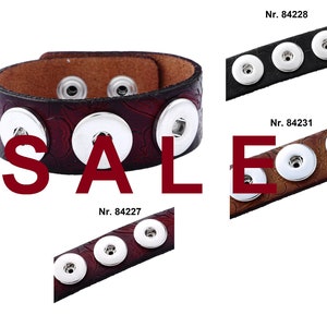 May include: Three leather bracelets with snap buttons. The bracelets are brown, black, and brown with a floral pattern. The bracelets are all on sale.