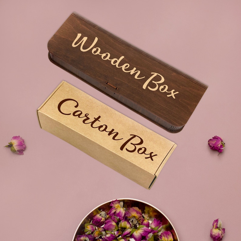Op de afbeelding: Twee dozen, een van hout en een van karton, beide met de woorden "Wooden Box" en "Carton Box" erop gedrukt in een bruin cursief schrift.