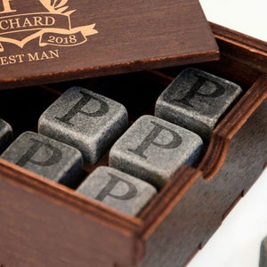 May include: A wooden box with a personalized inscription that reads "Richard 16.10. 2018 Best Man". The box contains a set of gray stone whiskey chilling cubes, each engraved with the letter "P".