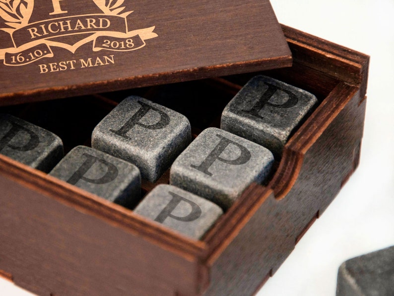 May include: A wooden box with a personalized inscription that reads "Richard 16.10. 2018 Best Man". The box contains a set of gray stone whiskey chilling cubes, each engraved with the letter "P".