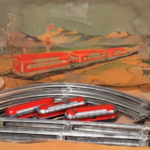 May include: A vintage toy train set with three red train cars and a silver track. The train cars have black windows and silver accents. The track is curved and has a wooden base.