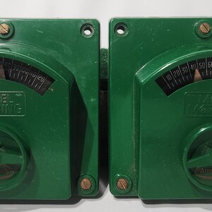 May include: Two vintage green gauges with black and white markings. Each gauge has a curved scale from 0 to 100, with the text "MODEL Mooring" visible. The gauges have a circular dial at the bottom.