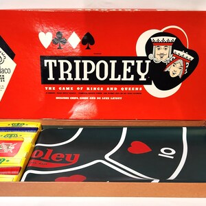 May include: A red box with the words "Tripoley The Game of Kings and Queens" on the front. The box is open and shows the game board, which is green with a red heart and the number 10 on it. The box also contains cards and chips.