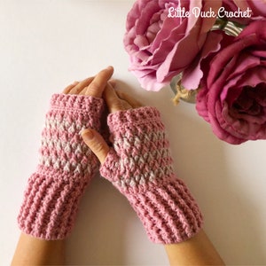 May include: A pair of pink and white striped fingerless gloves with a crocheted texture. The gloves are made with a soft yarn and have a comfortable fit.