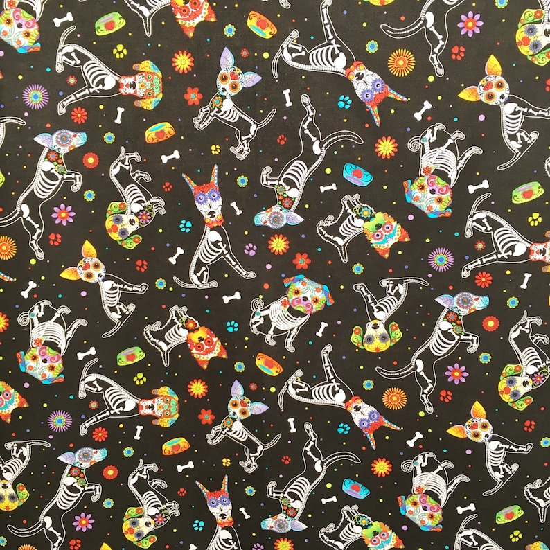 May include: Black fabric with a repeating pattern of white skeleton dogs with colorful flowers and skulls. The dogs are in various poses, some are standing, some are sitting, and some are running.