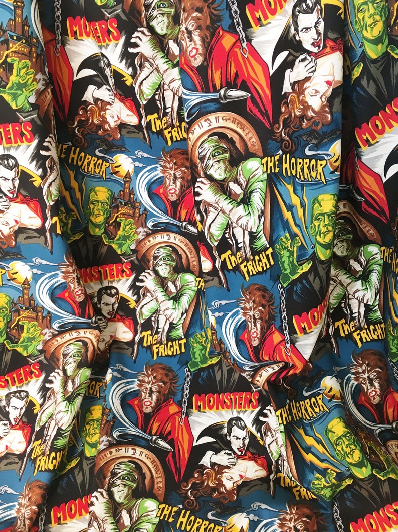 May include: A blue fabric with a repeating pattern of vintage movie posters featuring classic horror monsters. The posters feature images of Dracula, Frankenstein's monster, the Mummy, and the Wolfman. The text on the posters includes "Monsters", "The Horror", and "The Fright".
